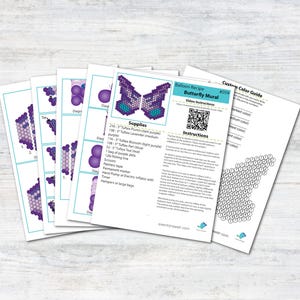 May include: Balloon animal craft instructions for a butterfly mural. The instructions include a list of supplies, a color guide, and a QR code for video instructions. The butterfly is made with purple, lavender, and blue balloons.