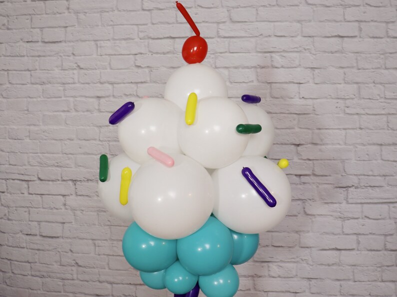 Pu&ograve; includere: Una scultura di cono gelato a palloncino con palloncini bianchi per il gelato, palloncini blu per il cono e palloncini colorati per le code.