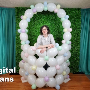 May include: A white balloon arch with pastel coloured balloons, forming a basket shape. A person is standing behind the balloon arch, with their arms crossed. The text "Digital Plans" is visible in the bottom left corner of the image.