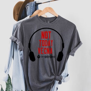 May include: A gray t-shirt with a black headphone graphic and the text "NOT TODAY VECNA" in red. The graphic also includes a Spotify logo and a barcode.