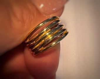 May include: A gold ring with multiple bands stacked on top of each other.