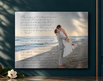 May include: A rectangular metal wall art print featuring a photograph of a couple embracing on a sandy beach at sunset, overlaid with cursive black text. The image shows a person in a white dress being lifted by a person in a gray suit.