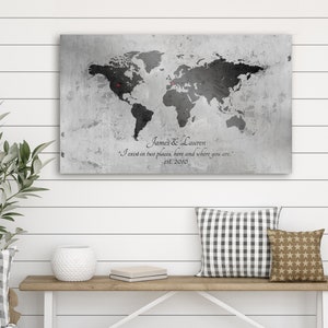 May include: A black and white world map print on a gray textured canvas with the text "James & Lauren I exist in two places, here and where you are. est. 2010".