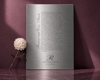 Pode incluir: Uma placa retangular de metal prateado escovado com texto impresso em preto. O texto inclui a frase Forever and Ever, Amen, um longo parágrafo de votos de casamento, a inicial R, os nomes Ashlee & Gregory Beeven e 10.30.2016.
