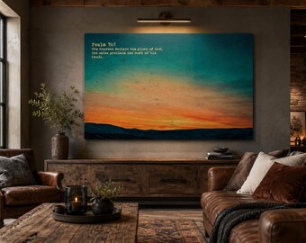 May include: A rectangular wall art print featuring a sunset landscape with a gradient of deep blue, orange, and yellow hues over dark silhouettes of hills. The text Psalm 19:1, The heavens declare the glory of God; the skies proclaim the work of his hands is printed in the upper left corner in a white serif font.