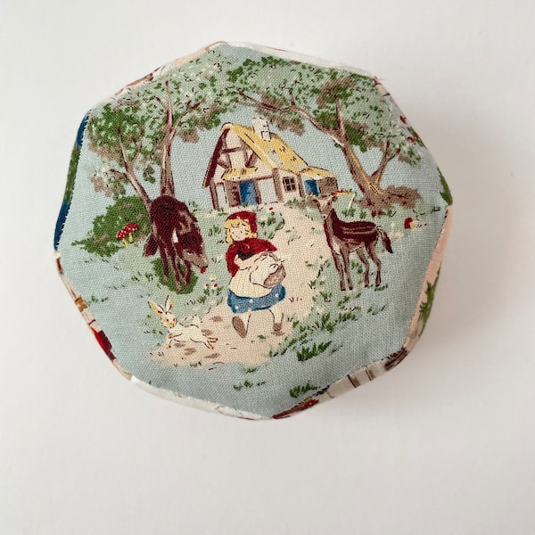 Octagon shaped, English paper pieced pin cushion featuring Red Riding Hood.