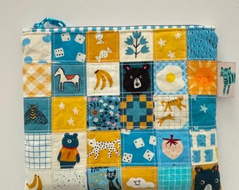 Bolsa grande con cremallera, de tela de algodón acolchada, con diseño de retazos en azul y amarillo.