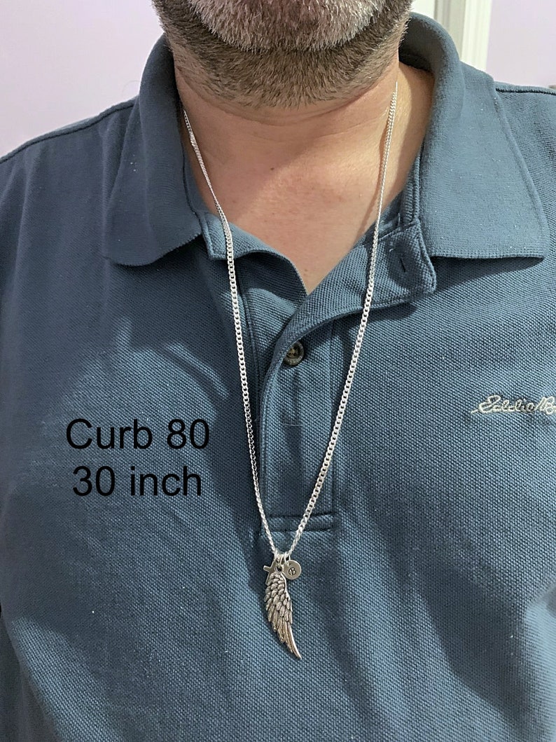 May include: A silver curb chain necklace with a silver wing pendant and a small round charm. The chain is 30 inches long and is labeled "Curb 80".