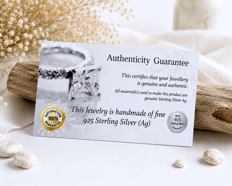 May include: A rectangular white authenticity guarantee card featuring a photograph of a square-cut gemstone ring. The text reads Authenticity Guarantee, This certifies that your Jewellery is genuine and authentic, and This Jewelry is handmade of fine 925 Sterling Silver (Ag).
