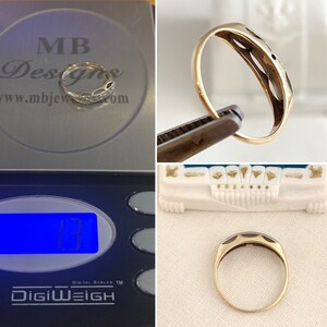 May include: A gold ring with a delicate design and a small stone in the center. The ring is being weighed on a digital scale that reads 1.3 grams.