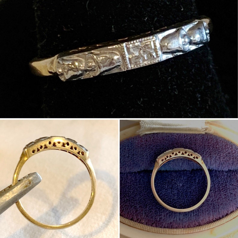 May include: A gold ring with a detailed, ornate design. The band features a series of small, square-shaped embellishments and a textured pattern. The ring is displayed against a dark background, highlighting its intricate details.