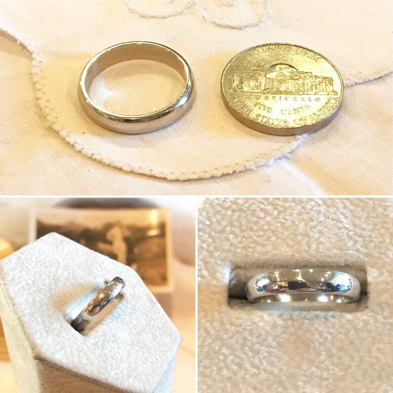 May include: Two silver wedding bands, one in a ring box and one next to a US five-cent coin. The coin is dated 1976 and features the Lincoln Memorial.