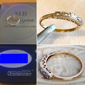 May include: A gold ring with a decorative band featuring small, square-shaped accents and a series of small, round cutouts. The ring is marked "14K" and is being weighed on a digital scale. The scale displays the text "DigiWeigh".