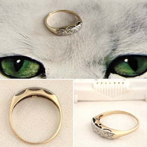 May include: A gold and silver ring with a delicate, intricate design. The ring is set with small, round stones.