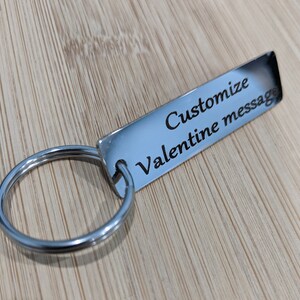 May include: Silver keychain with a rectangular tag that says "Customize Valentine message".