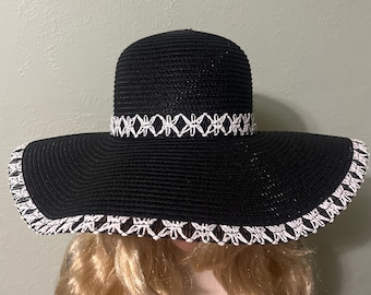 Sombrero de ala flexible para sol y playa. Estilo plegable. Preciosa paja negra con banda y ribete de crochet blanco alrededor del ala.