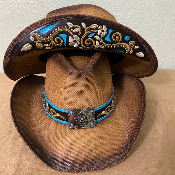 Chapeau de cowboy en paille avec de belles volutes appliquées sur chaque bord et un bandeau brodé assorti, médaillon en métal avec fausse pierre turquoise