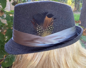Bord court Fedora en feutre gris.  Bracelet en satin gris avec de belles plumes
