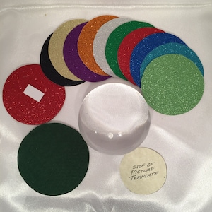 以下が含まれることがあります： 赤、緑、青、紫、金、銀など、さまざまな色の丸いグリッターペーパーの円が10個セットになっています。円は、中央に透明なガラスのドームがある半円形に配置されています。右下隅には、「画像テンプレートのサイズ」というテキストが書かれた小さな白い紙の円があります。