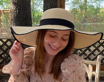 Sombrero de ala flexible para sol y playa. Hermoso tejido de paja negro y tostado con banda y lazo negros y colgante de diamantes de imitación en el lazo