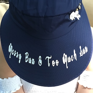 Blue Visor Foldable Hat with Pretty White Flowers Rhinestones and Studs. Monogrammed with "Messy Bun & Too Much Sun"