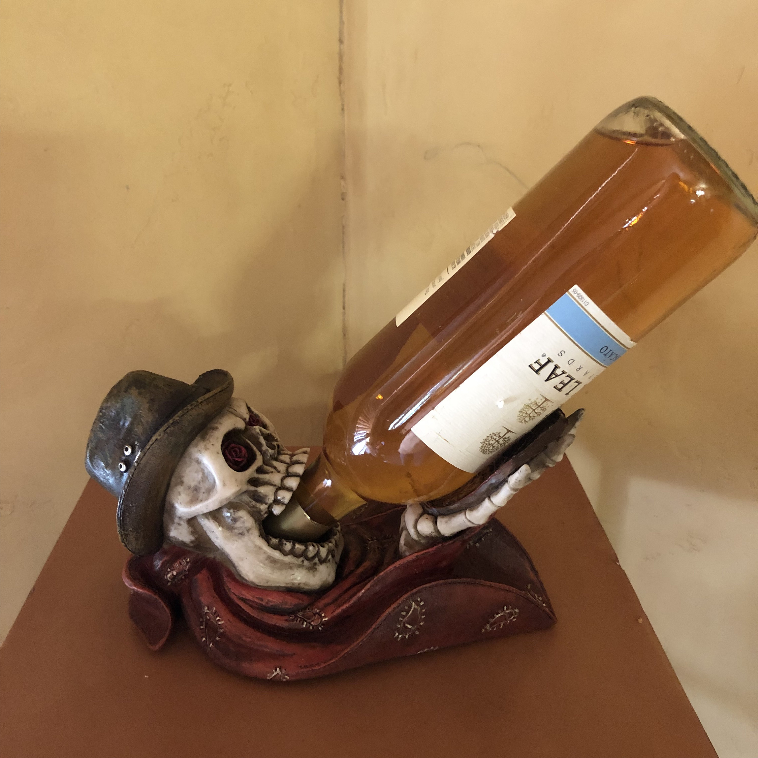 Cowboy skull wine holder wearing a hat and bandana