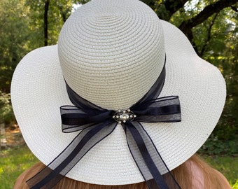 Sombrero de ala ancha para bodas, iglesias, sol y playa. Estilo plegable. Hermoso color blanco con cinta negra con lazo y detalle de joyas en el lazo.
