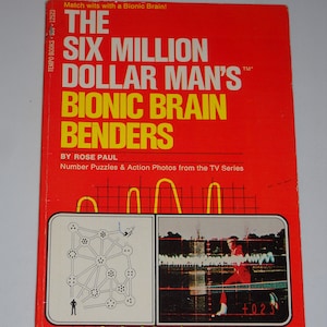 May include: A red book cover with the title "The Six Million Dollar Man's Bionic Brain Benders" by Rose Paul. The cover features a black and white illustration of a maze and a color photo of a man in a red jumpsuit running on a track.