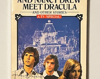 Op de afbeelding: Een boekomslag met de Hardy Boys en Nancy Drew, met de titel "The Hardy Boys and Nancy Drew Meet Dracula - And Other Stories - A TV 'Special'". De omslag toont een foto van de drie personages voor een groot, donker huis.