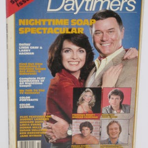 May include: A magazine cover for Daytimers, a magazine about daytime and nighttime soap operas. The cover features a photo of Linda Gray and Larry Hagman from the show Dallas. The cover text reads "Nighttime Soap Spectacular" and includes a list of other soap operas and actors featured in the issue.