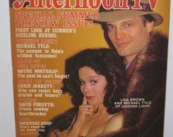 Op de afbeelding: Een tijdschriftcover voor Afternoon TV, met een speciale zomerpreview-editie. De cover toont acteurs Michael Tylo en Lisa Brown uit de soapseries Guiding Light en Days of Our Lives. De covertekst bevat de titel van het tijdschrift, de uitgave datum en de namen van de acteurs.