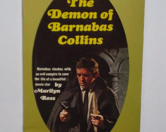 Op de afbeelding: Vintage paperback boekomslag met de titel "The Demon of Barnabas Collins" in gele tekst op een zwarte ovaal. De omslag toont een man in een donkere jas en de tekst "A new novel of suspense based on ABC-TV's DARK SHADOWS."