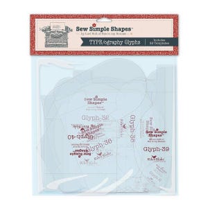 May include: A package of sewing templates labeled "Sew Simple Shapes" by Lori Holt. The package includes various glyph templates, with text such as "Glyph-32", "Glyph-35", "Glyph-36", "Glyph-39", and "Glyph-40". The package is clear with a red and white header.
