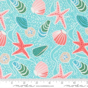 May include: A fabric with a repeating pattern of seashells, starfish, and sand dollars in shades of pink, green, and beige on a light blue background. The fabric has a dotted texture and white wavy lines. The fabric is marked with a ruler in inches.