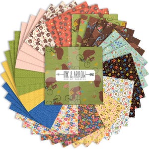 May include: A collection of fabric squares in various patterns and colors. Designs include bears on bicycles, floral prints, and geometric shapes. The fabric bundle is labeled "INK & ARROW FOR QT FABRICS."
