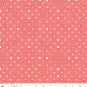 May include: A coral pink fabric with a white x pattern. The fabric is a repeating pattern of small white x's on a solid coral pink background.