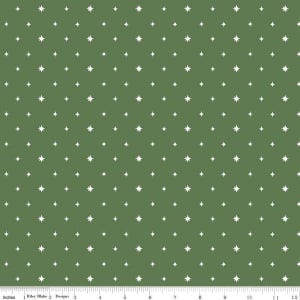 May include: Green fabric with a repeating pattern of white starbursts. The stars are evenly spaced across the fabric. The image includes a ruler with inch measurements along the bottom. The text "Riley Blake Designs" is also visible.