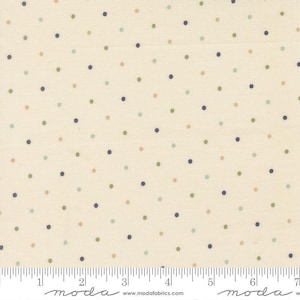 May include: A cream-colored fabric featuring a repeating pattern of small, evenly spaced polka dots in shades of dark blue, sage green, and tan. A white ruler is visible at the bottom, showing measurements in inches up to 7 inches.