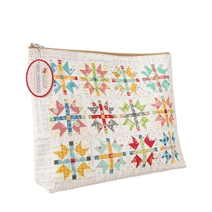 May include: A white vinyl zipper pouch with a patchwork design featuring red, blue, yellow, and green squares. The pouch has a zipper closure and a label that reads "Holiday Vinyl Zipper Pouch".