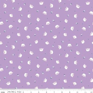 May include: A lavender fabric with a repeating pattern of white sheep and small blue flowers. The fabric also features small gray dots. The bottom of the fabric has a ruler with inches.