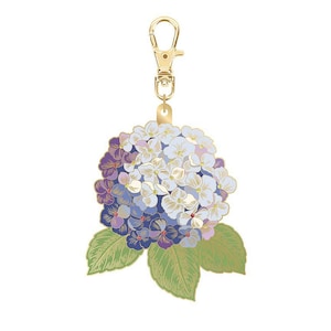 May include: A gold-colored metal keychain with a detailed hydrangea flower charm. The flower features shades of purple, blue, and white petals, with green leaves. The keychain has a lobster clasp for easy attachment.