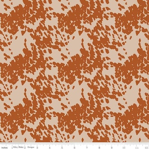 May include: A seamless fabric pattern with a brown and beige cowhide print. The pattern is a repeating design of brown spots on a beige background.
