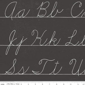 May include: A black chalkboard with white cursive letters of the alphabet, starting with Aa Bb C, then Jj Kk Lt, and ending with Ss Tt U. The letters are written on lines with a ruler underneath, marked in inches.