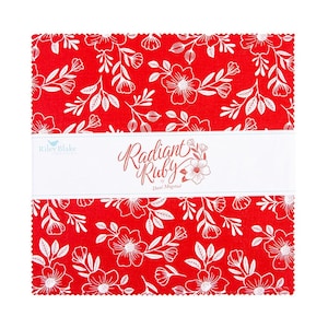 May include: A stack of red fabric squares with a white floral pattern. The fabric is labeled "Radiant Ruby" by Dani Mogstad. The Riley Blake logo is visible on the left side of the label.