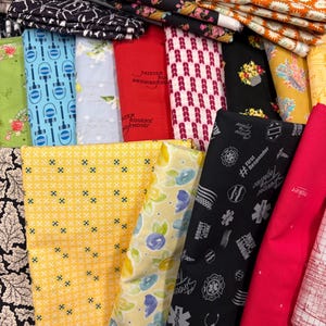 May include: A collection of various fabric patterns, including floral, geometric, and text-based designs. Colors range from black, red, yellow, and blue. Some fabrics feature text like "Mister Rogers' Neighborhood" and "First Responder".