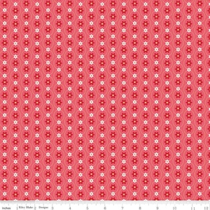 May include: A pink fabric with a repeating pattern of white and red flowers. The flowers are arranged in vertical rows with a dotted line between each row.