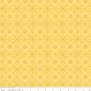 May include: Yellow fabric with a repeating floral pattern. The design features diamond shapes with dotted lines and stylized flowers. The fabric is measured in inches, with a ruler along the bottom edge.
