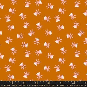 May include: A fabric with a repeating floral pattern. The flowers are pink and white, set against a burnt orange background. The flowers are small and scattered across the fabric. The fabric has a smooth texture.