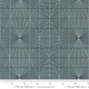 May include: A teal fabric featuring a repeating geometric pattern of dark lines forming diamond shapes and radiating starbursts. A white ruler is visible at the bottom edge, showing measurements in inches from 0 to 7, with the text moda and www.modafabrics.com.