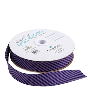 May include: A spool of eggplant purple and lavender striped single-fold quilt binding tape. The label reads "Single-Fold Quilt Binding" and "Stripes". The tape is 2.5 inches wide and made of 100% cotton.